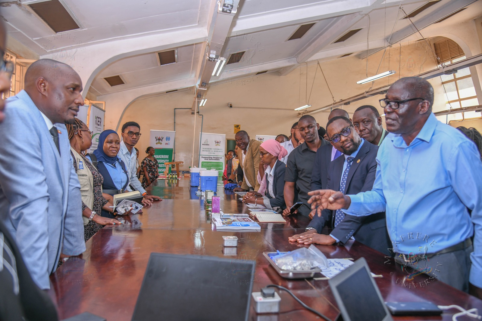 Hon. Eng. Jonard Asiimwe Akiiki interacts with Prof. Livex Okwi during his inspection of exhibitions. Hon. Eng. Jonard Asiimwe Akiiki, Minister of Science, Technology and Innovation in the Office of the President, two-day Ministerial Maiden Visit to Makerere University, 21st-22nd July 2026, Kampala Uganda, East Africa.
