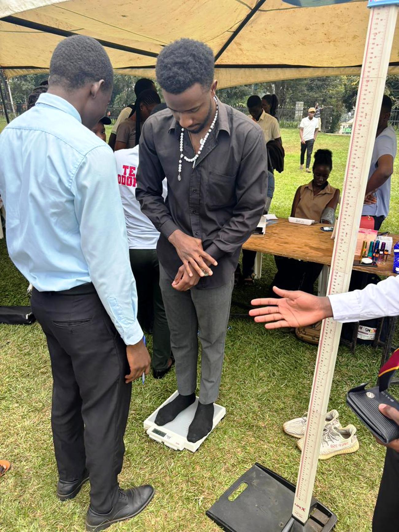 A male client gets his BMI checked. The 91st Guild Ministry of Health Annual Makerere Guild Medical Camp, 3rd and 4th October 2025, Freedom Square, Makerere University, Kampala Uganda, East Africa.