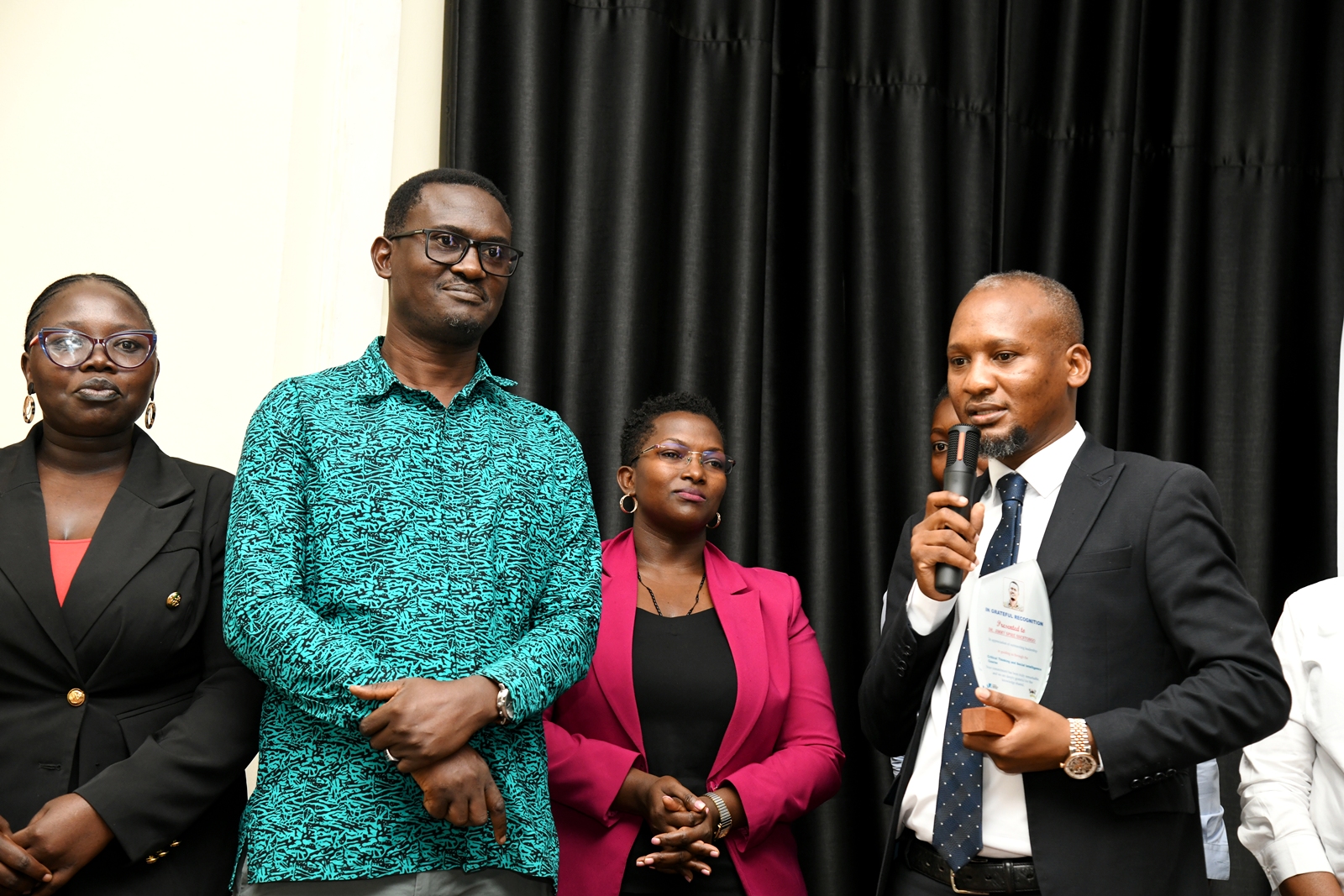 Mr. Boniface Clever Lukwago (R) makes a few remarks prior to presenting Dr. Ssentongo with a plaque. Award ceremony for the pioneer cohort of the Certificate in Critical Thinking and Social Intelligence, a short course offered by the Department of Philosophy in the School of Liberal and Performing Arts, College of Humanities and Social Sciences (CHUSS) with support from Konrad Adenauer Stiftung and UNESCO. 7th August 2026, Conference Hall, School of Food Technology, Nutrition and Bioengineering, CAES, Makerere University, Kampala Uganda.