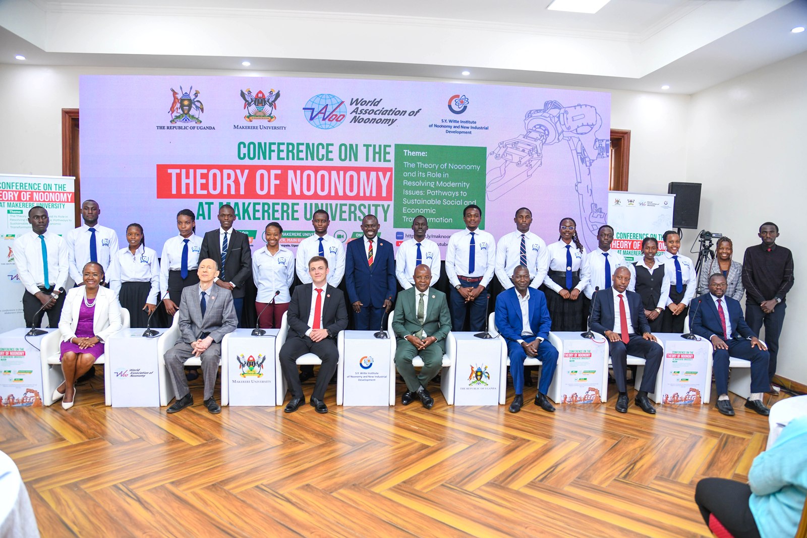 Seated L-R: Prof. Sarah Ssali, Mr. Sergey Lobanov-Head of Mission, Russian Embassy in Uganda, Prof. Nikolay D. Dmitriev, Prof. Edward Bbaale, Dr. Robert Ngobi, Mr. Davis Vuningoma and Prof. Ibrahim Mike Okumu with Dr. Peter Babyenda and CoBAMS Students (Standing) on 20th August 2026. College of Business and Management Sciences (CoBAMS) supported by the Makerere University Research and Innovations Fund (Mak-RIF) in collaboration with the Witte Institute for New Industrial Development and St. Petersburg Polytechnic University, Russia Conference on The Theory of Noonomy and its Role in Resolving Modernity Issues: Pathways to Sustainable Social and Economic Transformation, 20th Aug 2026, Senior Common Room, Main Building, Makerere University, Kampala Uganda, East Africa