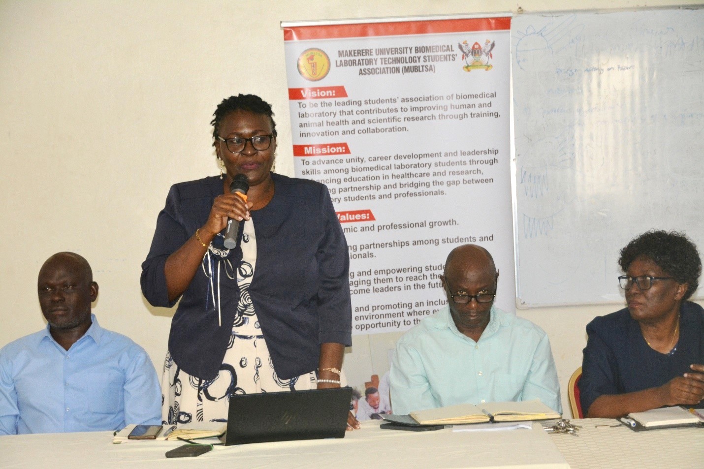 Assoc. Prof. Claire Mack Mugasa, Dean of SBLS, (2ND R) addresses the incoming Biomedical Laboratory Technology class at Makerere University, congratulating them on making ‘one of the best decisions of your lives’. School of Biosecurity, Biotechnical and Laboratory (SBLS) orientation for undergraduate and postgraduate students, 4th August 2026,e College of Veterinary Medicine, Animal Resources and Biosecurity (CoVAB), Makerere University, Kampala Uganda, East Africa.