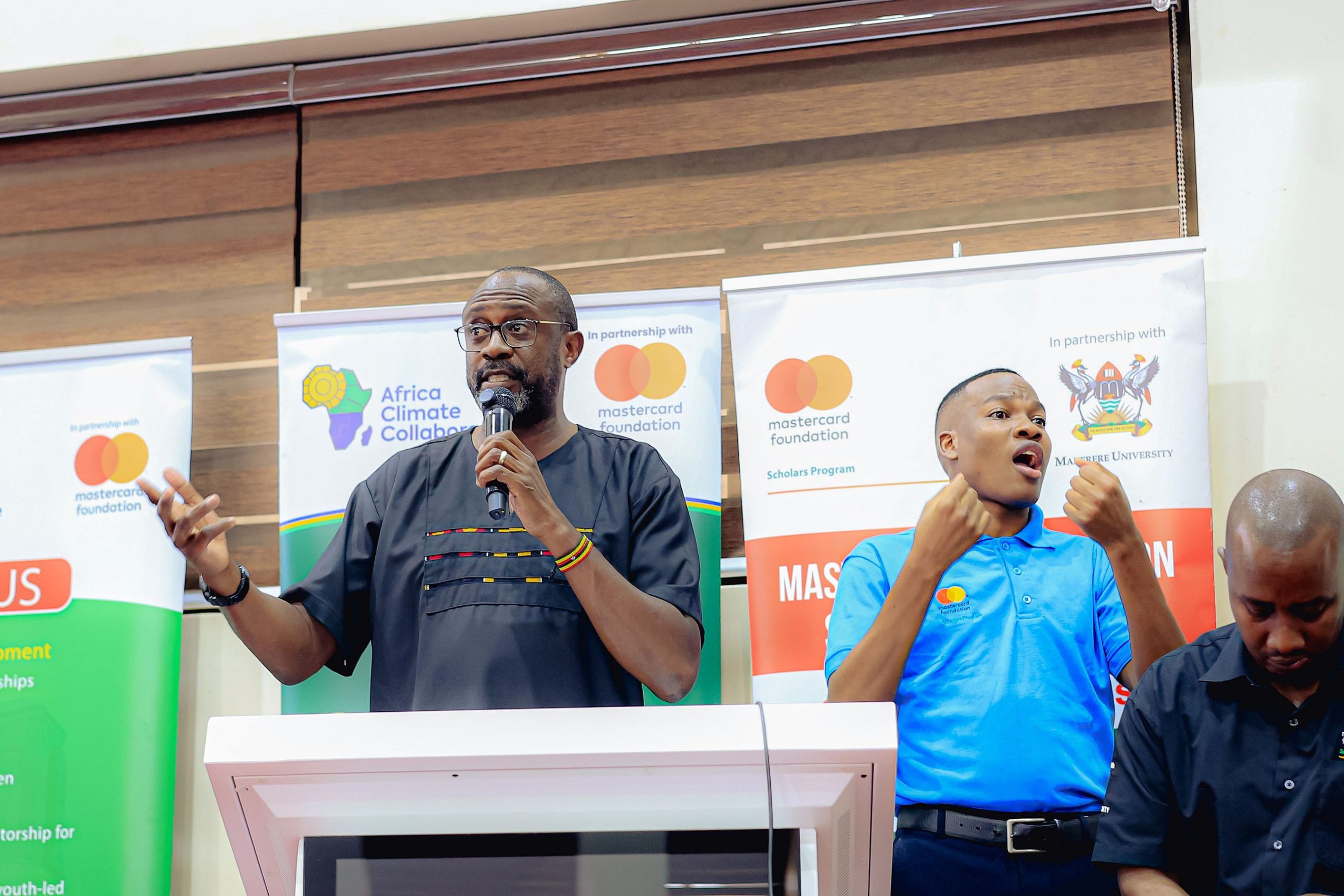 Mr. Adrian Bukenya, speaking at the event. Award Ceremony for Cohort 9 of 258 recipients of the prestigious Mastercard Foundation scholarship for the 2026/2027 academic, 20th August 2026, Makerere University School of Public Health (MakSPH) Auditorium, Main Campus, Kampala Uganda, East Africa.