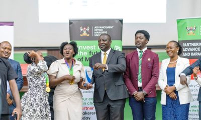 Moment of Truth! Hon. Eng. Cuthbert Abigaba (Centre) presents a trophy to the winning team as DVCAA-Prof. Sarah Ssali, 92nd Vice Guild President-H.E. John Bosco Mubiru and other officials witness on 31st July 2026. East African Universities Debate Championships 2026 (EAUDC ZAABU) Closing Ceremony, 31st July 2026, Main Hall, Makerere University, Kampala Uganda.