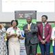 Moment of Truth! Hon. Eng. Cuthbert Abigaba (Centre) presents a trophy to the winning team as DVCAA-Prof. Sarah Ssali, 92nd Vice Guild President-H.E. John Bosco Mubiru and other officials witness on 31st July 2026. East African Universities Debate Championships 2026 (EAUDC ZAABU) Closing Ceremony, 31st July 2026, Main Hall, Makerere University, Kampala Uganda.
