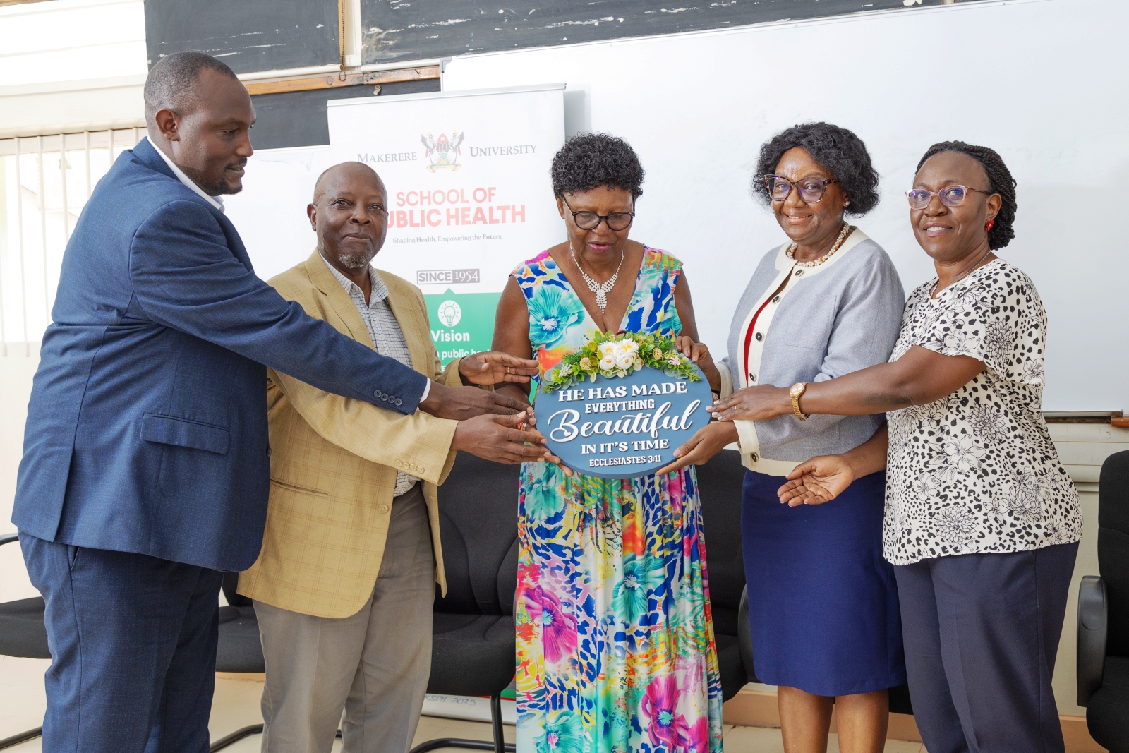 Claire Nakayizi receives a plaque in appreciation of her service from the Dean and Leaderhship of SPH. Celebrating Claire Nakayizi's 14 years of service as Custodian, August 2026, Makerere University School of Public Health (MakSPH), Mulago Hospital Complex, Kampala Uganda, East Africa.