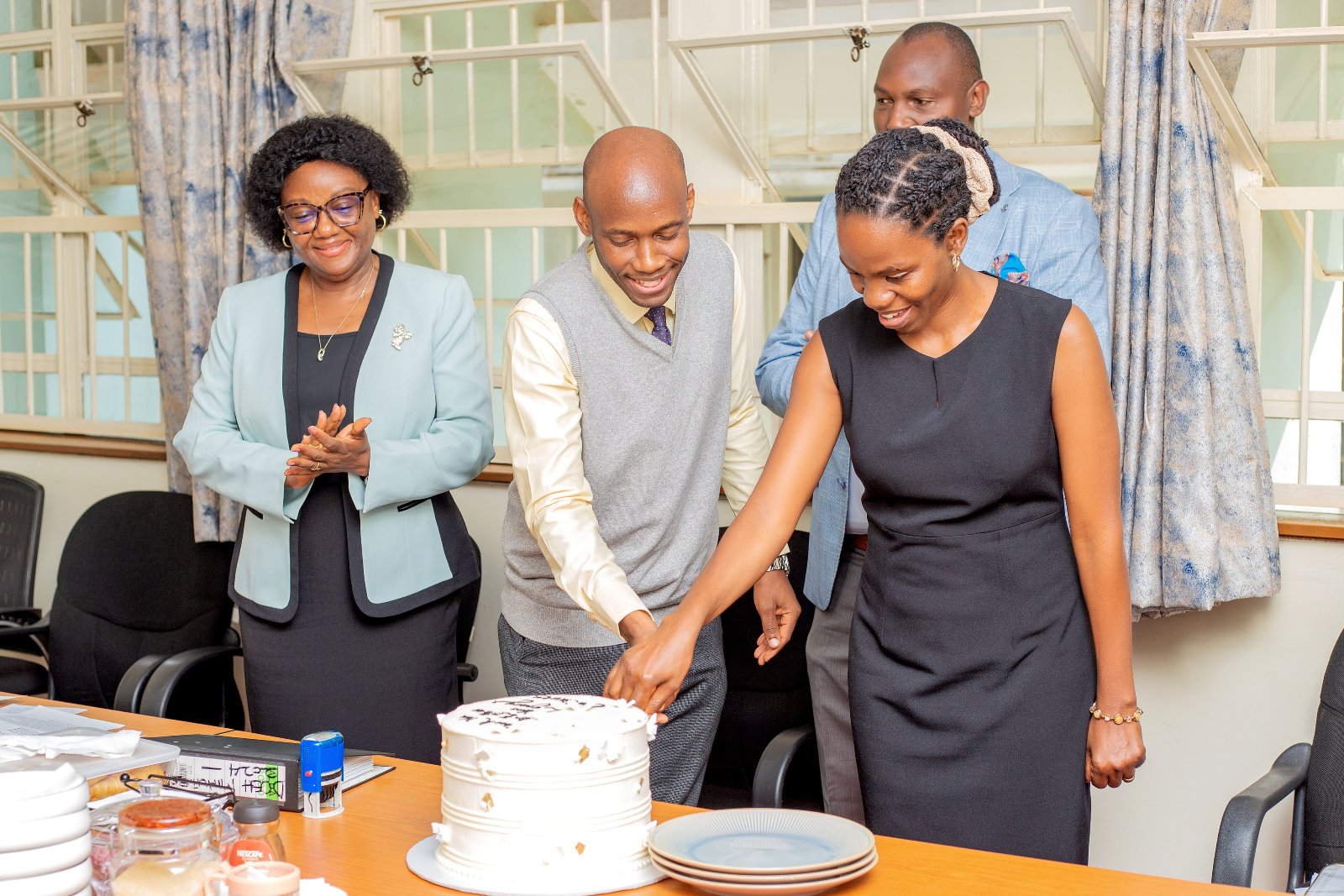 Dr. David Musoke and Dr. Esther Buregyeya cut cake at the handover ceremony. Makerere University School of Public Health (MakSPH) leadership transition, Department of Disease Control and Environmental Health, Dr. David Musoke takes over from Dr. Esther Buregyeya, 11th August 2026, Mulago Hospital Complex, Kampala Uganda, East Africa.
