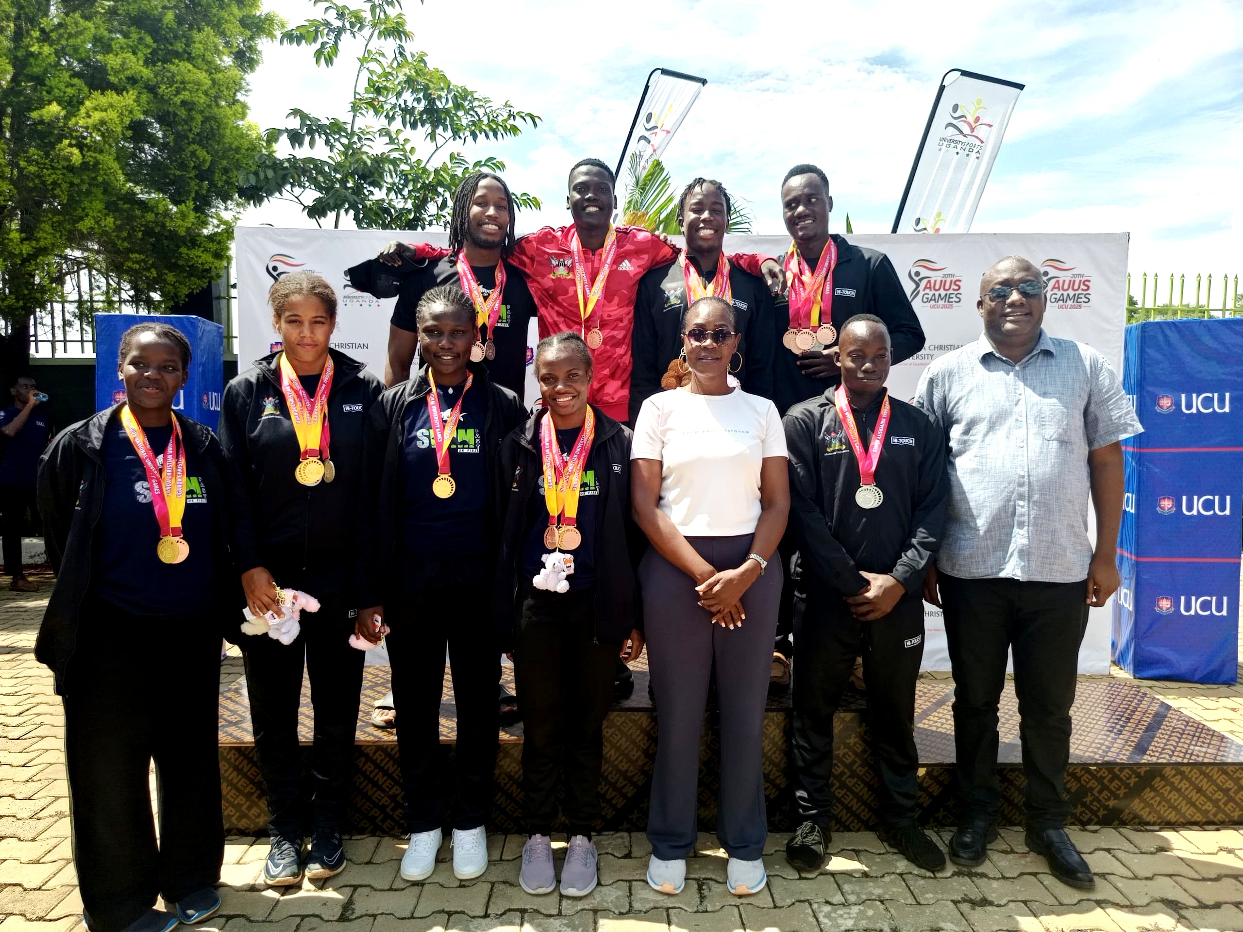 The Dean of Students, Dr. Winifred Kabumbuli and Deputy Dean In-Charge of Sports, Mr. Brian Miiro with the Mak Sharks Swim Team that won Gold in both Men and Women categories at the AUUS Games in 2025. Sports and Recreation Department, Makerere University, Kampala Uganda, East Africa.