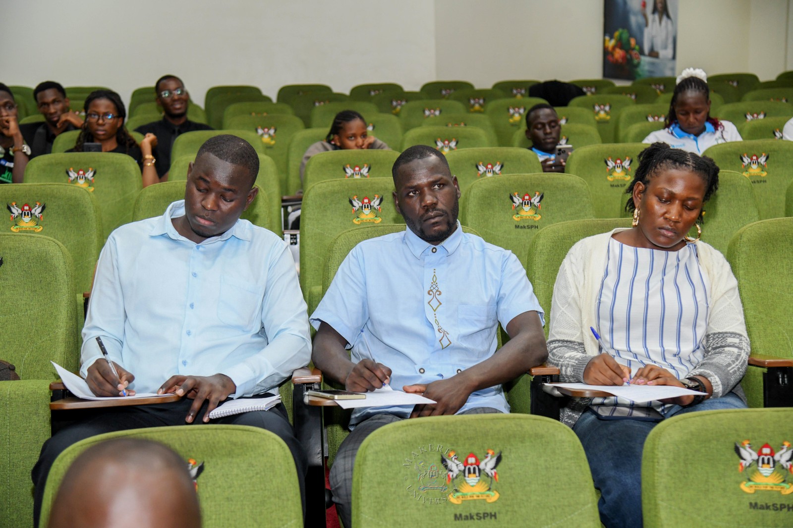 Coach Vincent Odong (C) takes notes during the event. 2nd National Inter University Debate Competition 2026 under the theme “Students Health, Safety and Well-Being: A Catalyst for enhanced educational outcomes and academic excellence in higher education institutions in Uganda.” where Makerere secured 2nd place in the grand finale, National level. School of Public Health Auditorium, 29th September 2026, Makerere University, Kampala Uganda, East Africa.