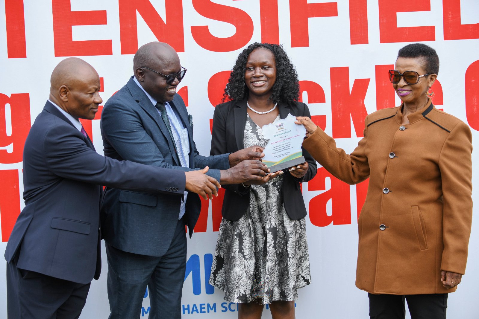 L-R: Prof. Josaphat Byamugisha, Prof. Richard Idro, and H.E. Kadondi Gracious present a plaque to Hon. Anifa Kawooya appreciating the Ministry of Health Support to the Medical Camp on 17th September 2026. Launch of the two-day 92nd Makerere University Guild Annual Medical Camp and intensified testing and active case finding for Malaria, HIV/AIDS and Sickle Cell Disease in universities and tertiary institutions, 17th September 2026, Freedom Square, Makerere University, Kampala Uganda, East Africa.