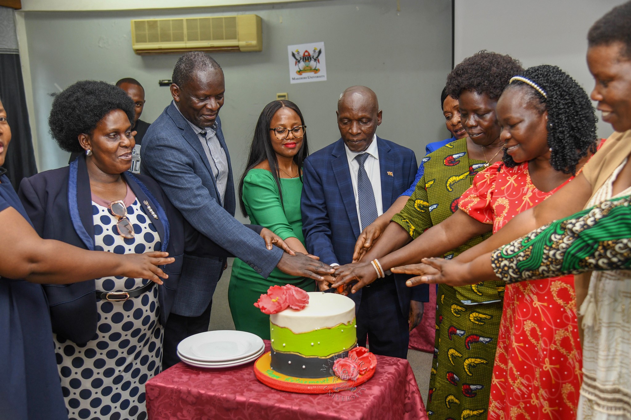 Mr. Charles Ssentongo (C) and Ms. Betty Akoli (3rd R) are joined by Staff and Family to cut cake at the farewell luncheon on 18th September 2026. Farewell Luncheon held by Department of Academic Registrar in honour of Mr. Charles Ssentongo, Deputy Academic Registrar – Undergraduate Admissions and Records and Ms. Betty Akoli, Assistant Academic Registrar presided over by Ag. Academic Registrar Ms. Prossie Nakayiki, 18th September 2026, Senate Conference Hal, Level 4, Senate Building, Makerere University, Kampala Uganda, East Africa.