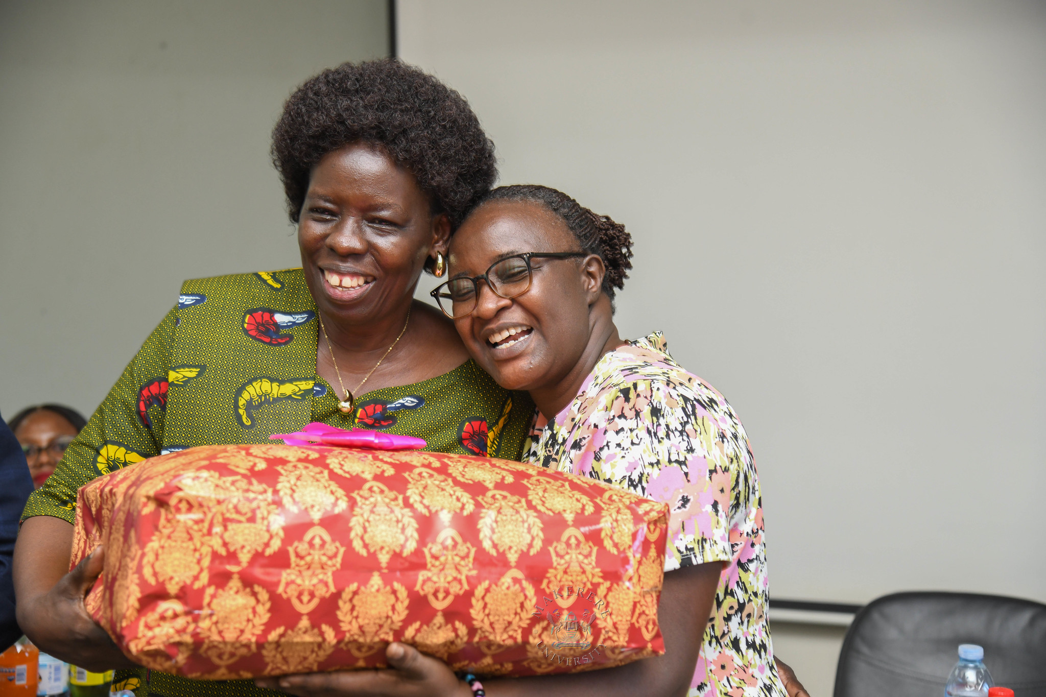 Ms. Betty Akoli receives a gift from a former colleague. Farewell Luncheon held by Department of Academic Registrar in honour of Mr. Charles Ssentongo, Deputy Academic Registrar – Undergraduate Admissions and Records and Ms. Betty Akoli, Assistant Academic Registrar presided over by Ag. Academic Registrar Ms. Prossie Nakayiki, 18th September 2026, Senate Conference Hal, Level 4, Senate Building, Makerere University, Kampala Uganda, East Africa.