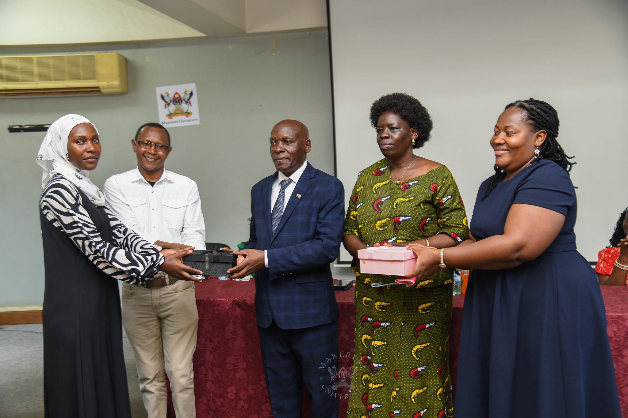 Mr. Ssentongo and Ms. Akoli receive gifts from staff of their former Units including Mr. Justus Karegyeya (2nd L) the Ag. Deputy Academic Registrar, Undergraduate Admissions and Records. Farewell Luncheon held by Department of Academic Registrar in honour of Mr. Charles Ssentongo, Deputy Academic Registrar – Undergraduate Admissions and Records and Ms. Betty Akoli, Assistant Academic Registrar presided over by Ag. Academic Registrar Ms. Prossie Nakayiki, 18th September 2026, Senate Conference Hal, Level 4, Senate Building, Makerere University, Kampala Uganda, East Africa.