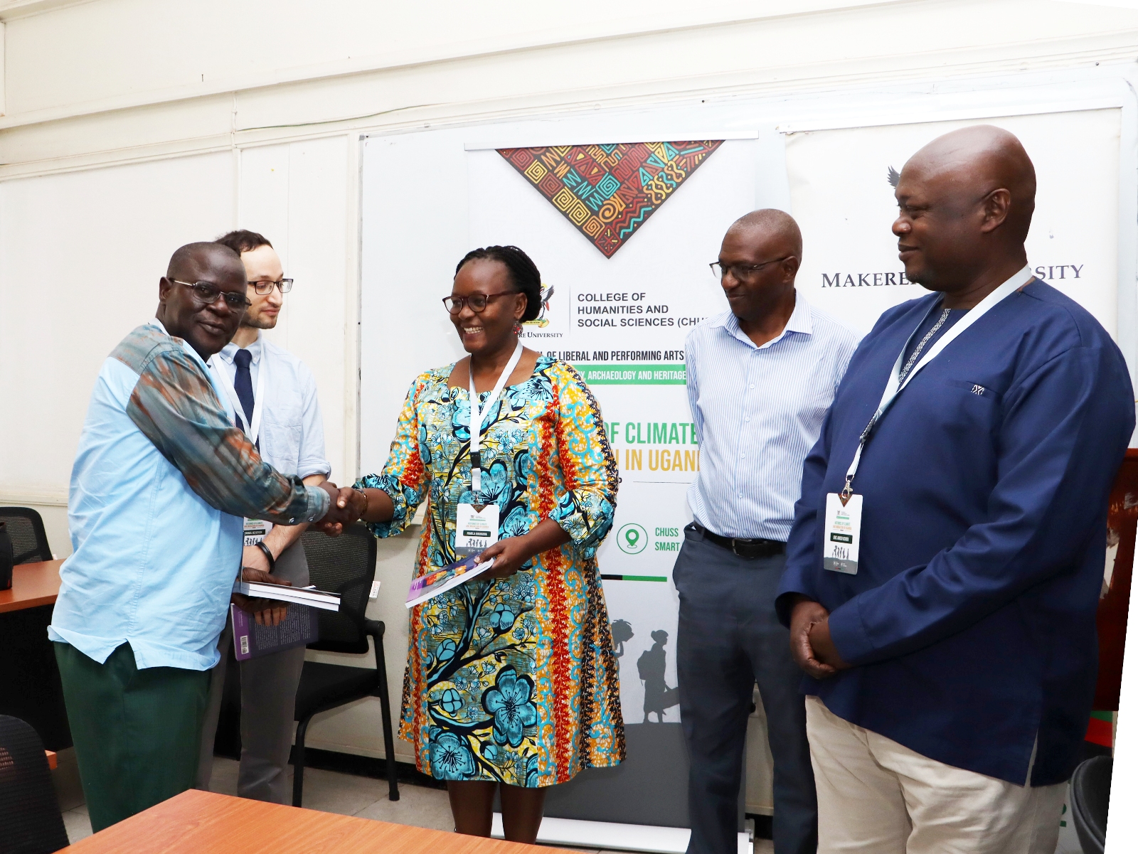 Dr. Anthony Mugeere giving his new book to Dr. Pamela Khanakwa. Opening Ceremony of three-day workshop hosted by the Department of History, Archaeology and Heritage Studies, School of Liberal and Performing Arts, College of Humanities and Social Sciences (CHUSS) examining the historical relationship between climate change and migration in Uganda, under a joint project between Makerere University and the University of Cambridge, CHUSS Smart Room, 8th-10th September 2026, Kampala Uganda, East Africa.