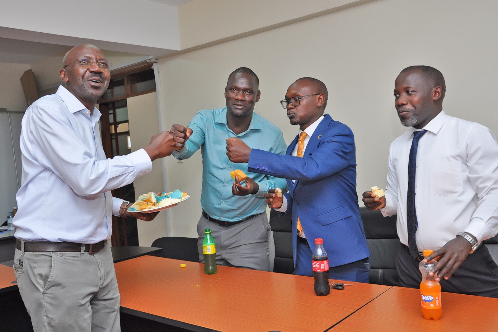 Mr. Peter Mubiru, shares a moment of fellowship with colleagues as he serves them cake. Mr. Peter Mubiru handover of the office of the College Bursar to Mr. George Lusiba, 31st August 2026, College of Business and Management Sciences (CoBAMS), Makerere University, Kampala Uganda, East Africa.