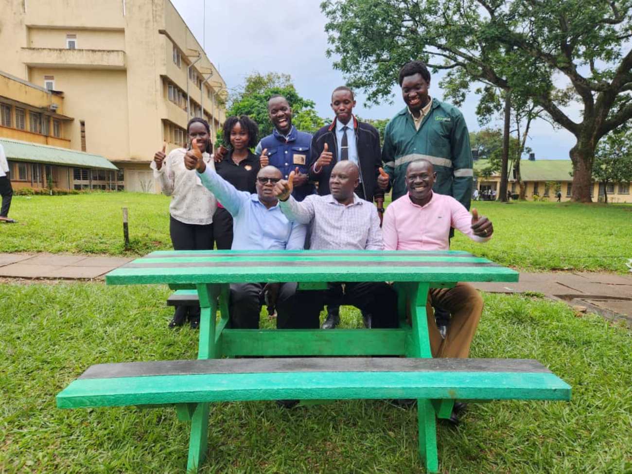 The founders of WastePlus Ltd led by Mr. Sinan Kitagenda with their former Lecturers, Dr. Jamilu E. Ssenku (C) and Dr Samuel Ojelel (R) from the Department of Plant Sciences, Microbiology and Biotechnology, as well as Dr Godfrey Kawooya Kubiriza, Head of the Department of Zoology, Entomology and Fisheries Sciences. The green table is one of the products made by the alumni out of plastic waste WastePlus Ltd, a waste management and recycling enterprise founded by BSc Conservation Biology from the Department of Plant Sciences, Microbiology and Biotechnology, School of Physical Sciences donation of furniture made from recycled plastic, August 2026, Science Quadrangle, College of Natural Sciences (CoNAS), Makerere University, Kampala Uganda, East Africa.