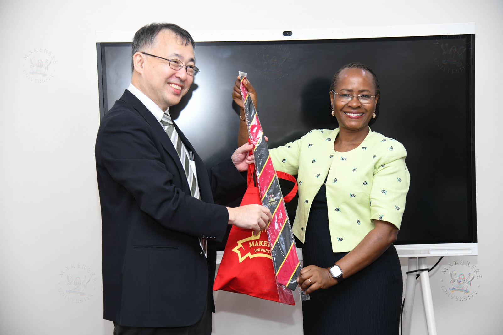 Prof. Sarah Ssali (R) presents a Makerere necktie to Dr. Okano Takasei (L). Japan International Cooperation Agency (JICA) delegation led by Dr. Okano Takasei meets DVCAA Prof. Sarah Ssali, explores new opportunities for strengthening academic, research and innovation collaboration between Uganda, Japan and other African countries, with a particular focus on artificial intelligence (AI), aerospace engineering, materials and remote sensing, food value chains, energy, water and climate change, 4th September 2026, Main Building, Makerere University, Kampala Uganda, East Africa.