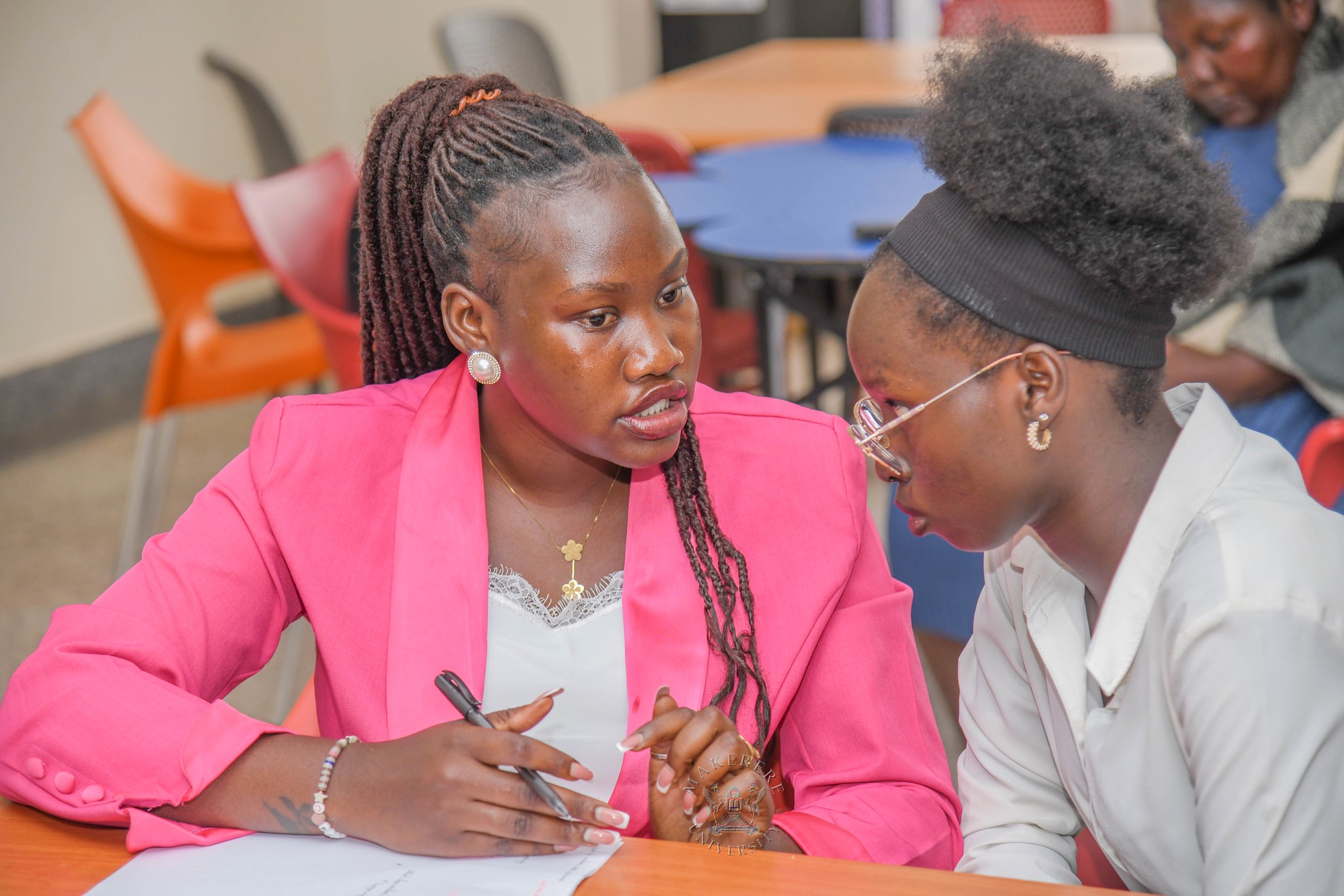 Makerere's Ms. Cynthia Apili (L) and Ms. Synthia Lamara (R) compare notes. 2nd National Inter University Debate Competition 2026 under the theme “Students Health, Safety and Well-Being: A Catalyst for enhanced educational outcomes and academic excellence in higher education institutions in Uganda.” where Makerere secured 2nd place in the grand finale, National level. School of Public Health Auditorium, 29th September 2026, Makerere University, Kampala Uganda, East Africa.