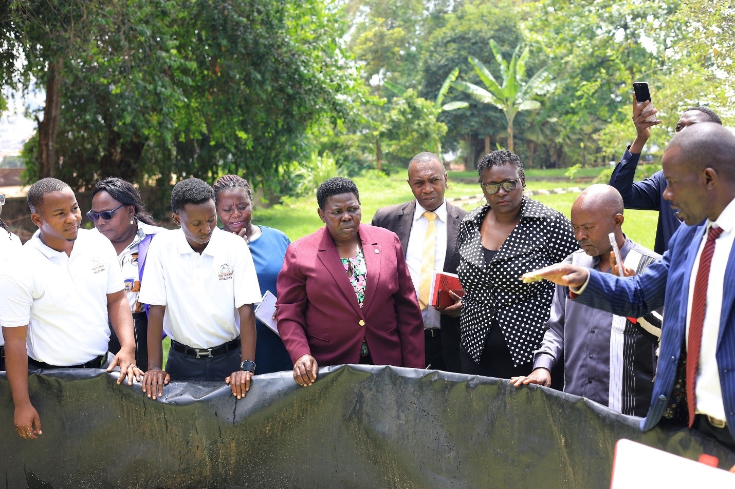 Dr. Herbert Mukiibi (Right) showing Ms. Namayanja, one of the demonstration tanks where AZOLLA is grown  at CoVAB. The Deputy Secretary General of the National Resistance Movement (NRM), Ms. Rose Namayanja visit to the College of Veterinary Medicine, Animal Resources and Biosecurity (CoVAB) to discuss azolla production, October 12, 2026, Makerere University, Kampala Uganda, East Africa.