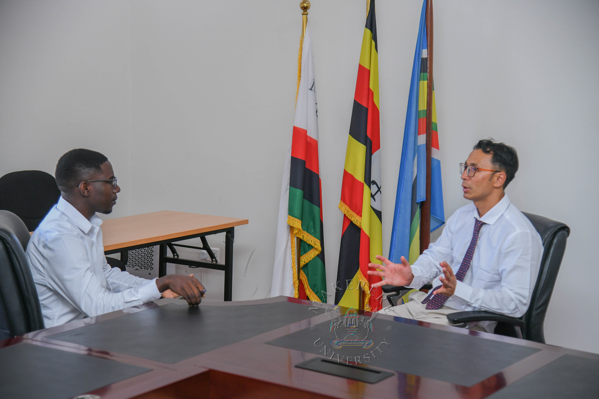 Professor AUNG with the article author. Public Relations Office interview with Professor Dr. Thiha AUNG, German oncology reconstruction specialist, surgeon, trainer at the Deggendorf Institute of Technology (THD), and researcher on cancer from the Deggendorf Institute of Technology (DIT), Germany. 7th October 2026, Main Building, Makerere University, Kampala Uganda, East Africa.